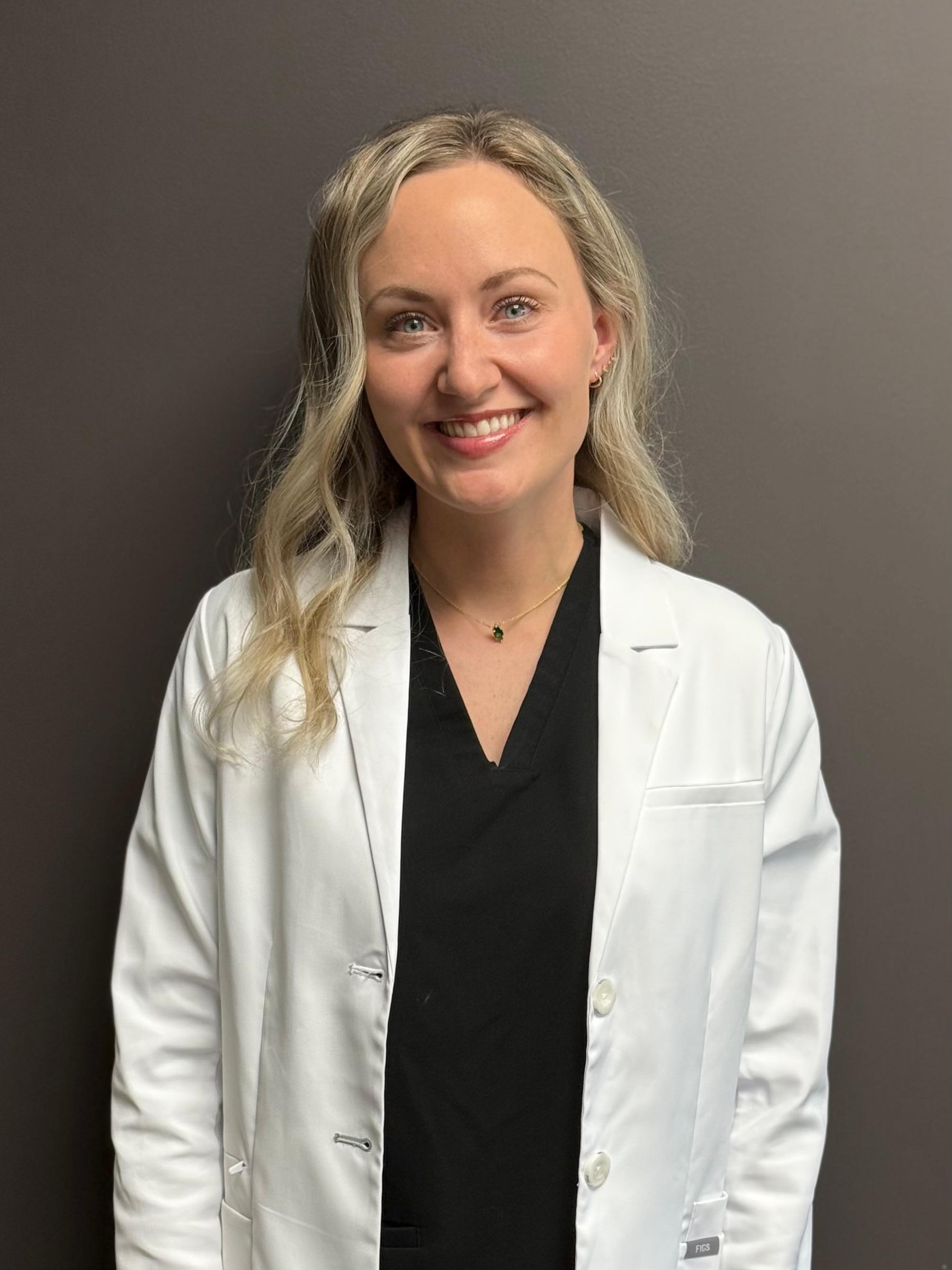 Dr. Elizebeth Presley, professional dentist, smiling warmly and wearing a white lab coat, showcasing expertise and dedication to exceptional dental care at Carmel Dental Care.